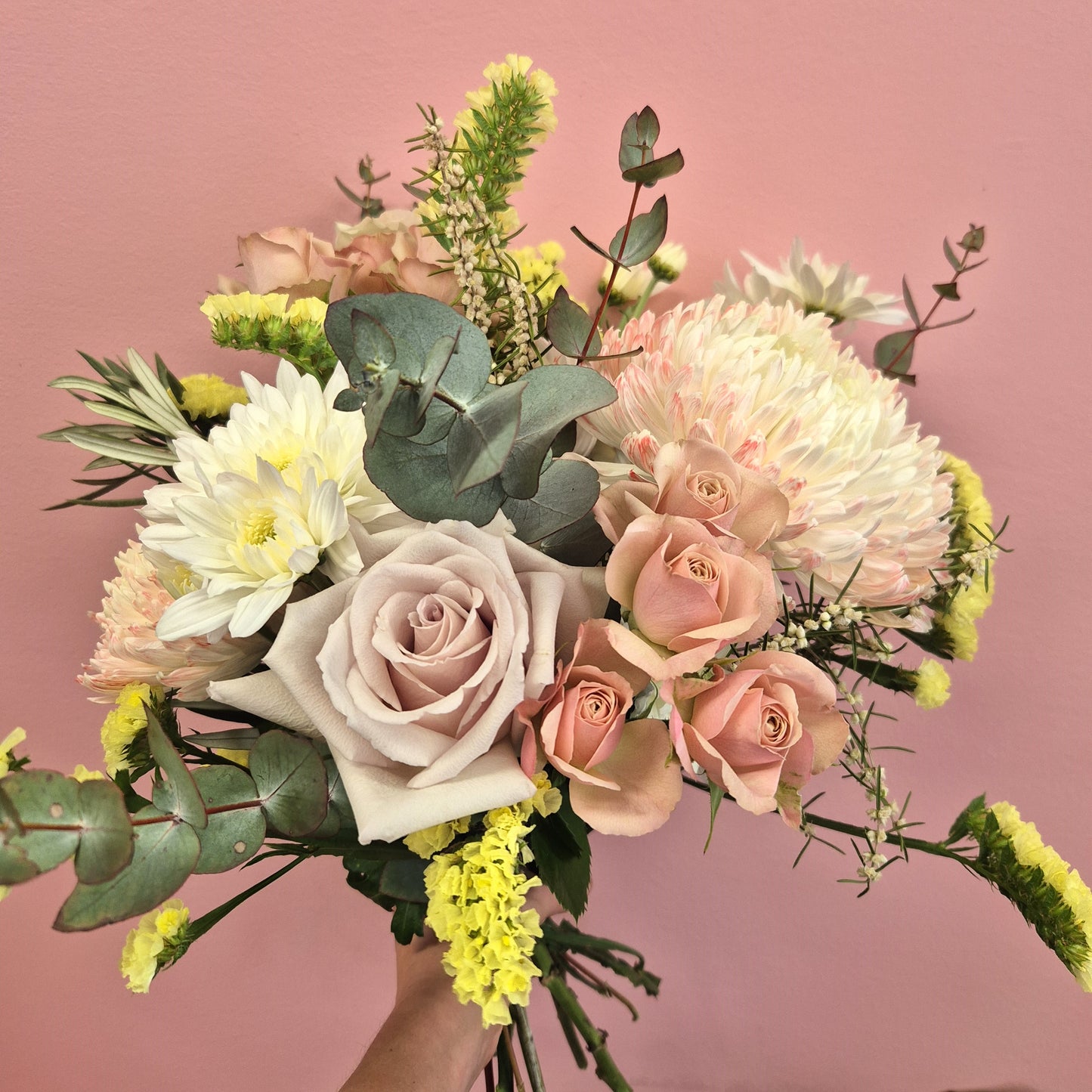 Bouquet of flowers with pink and white roses on a pink background