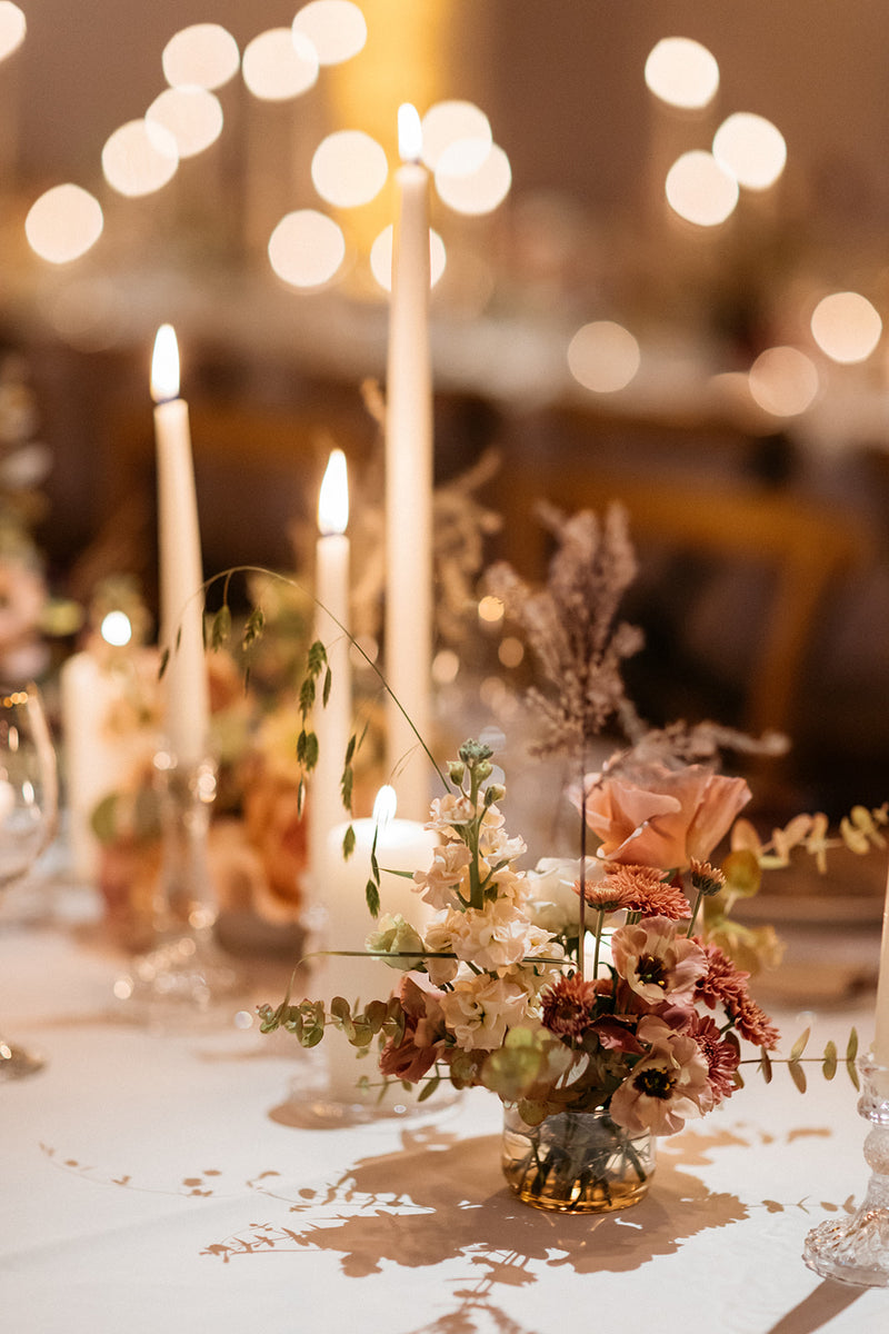 Decorative table setting with candles and flowers, blurred lights in the background in Sardinia, Italy