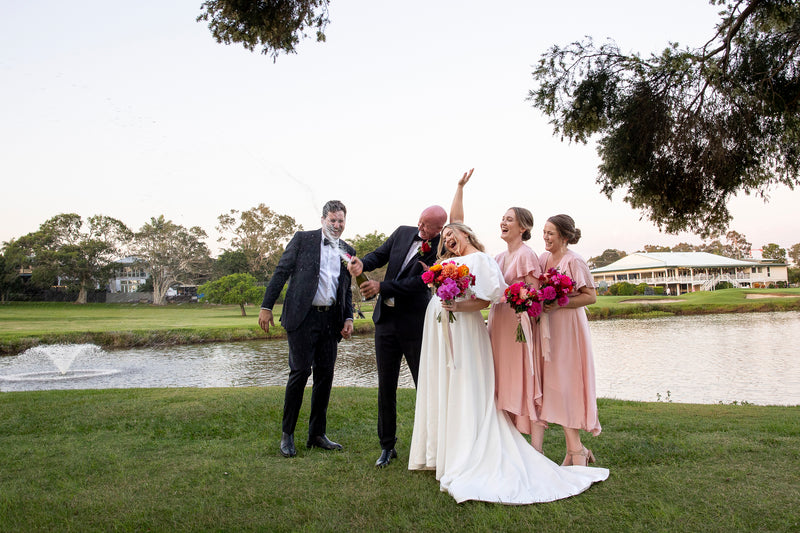 Wedding party with bride, groom and bridesmaids by a lake in Wynnum