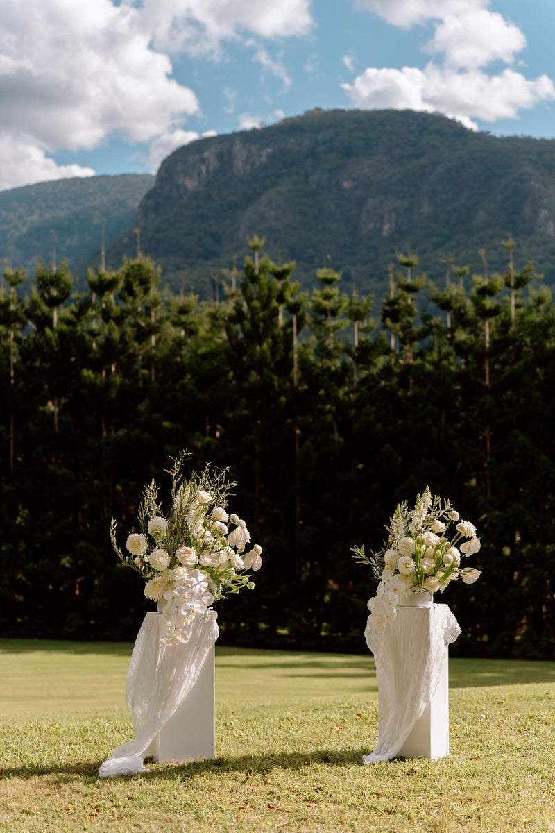 Two floral arrangements on stands with a mountainous background in the NSW hinterland near Byron Bay