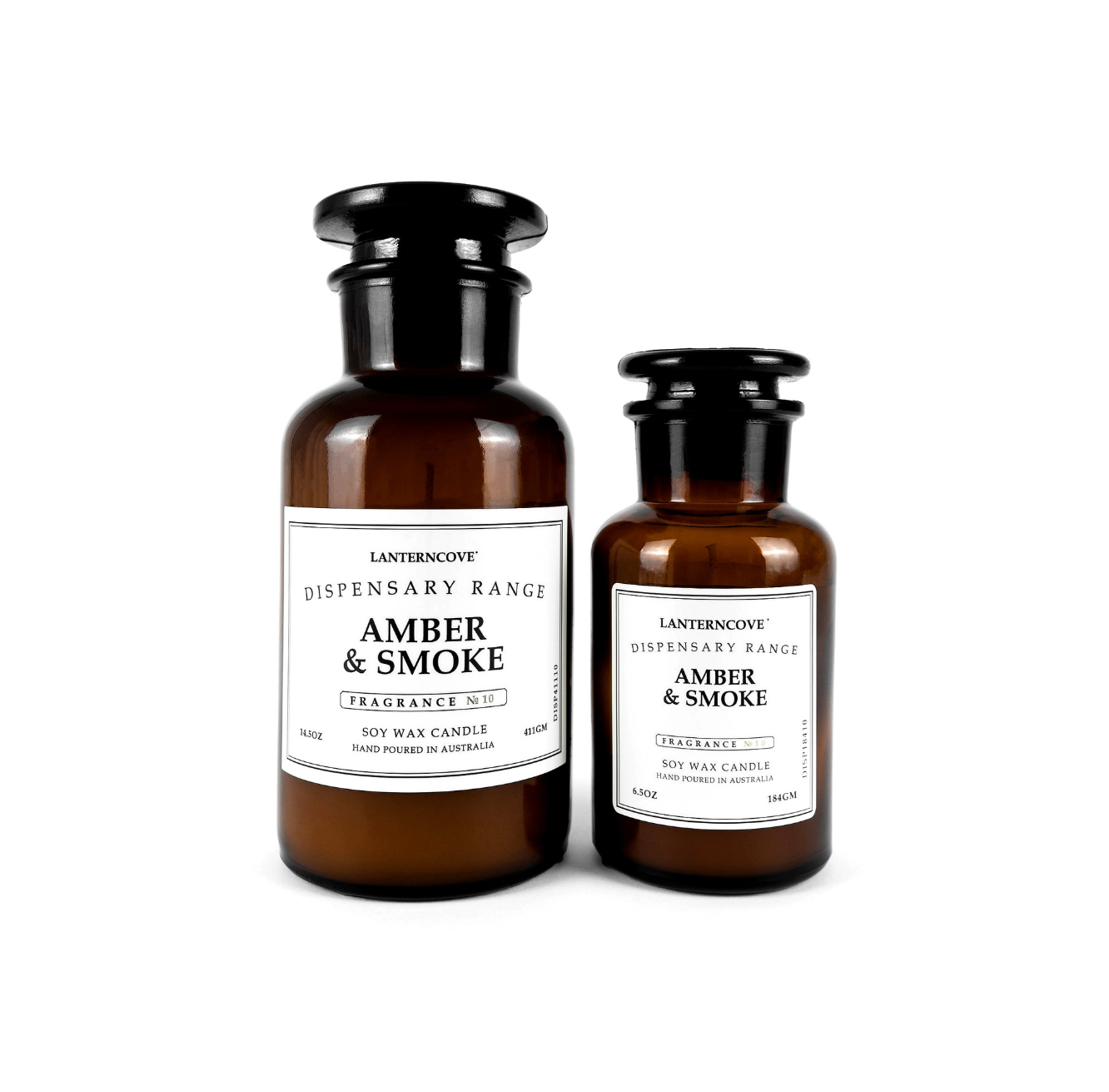 Two amber glass soy wax candles with black caps and white labels from Lantern Cove's Distensary Range, labeled 'Amber & Smoke', on a white background.