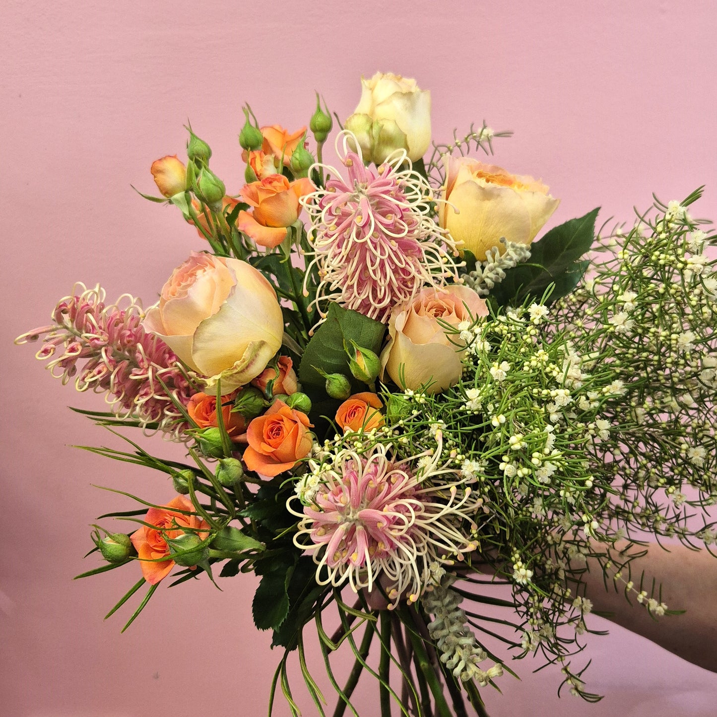 Bouquet of flowers with pink and orange tones on a pink background