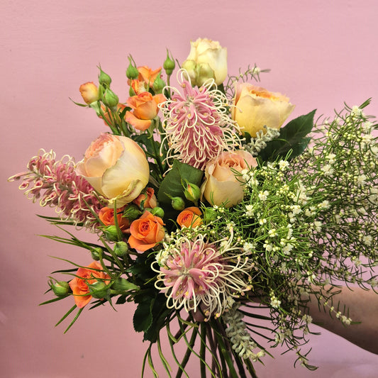 Bouquet of flowers with pink and orange tones on a pink background
